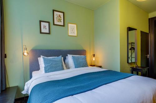 a bedroom with a large bed with blue and white pillows at SeventyFive in Amsterdam