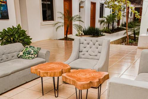 a living room with two couches and two tables at Los Vados Hotel in Managua