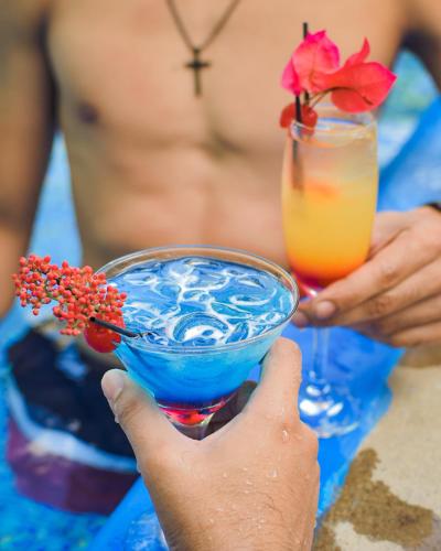 a woman holding up a blue drink with a martini at Los Vados Hotel in Managua