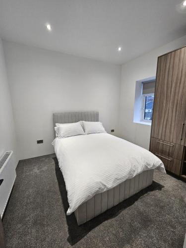Un dormitorio blanco con una cama grande y una ventana en Spectrum Apartments, en Clooney Park
