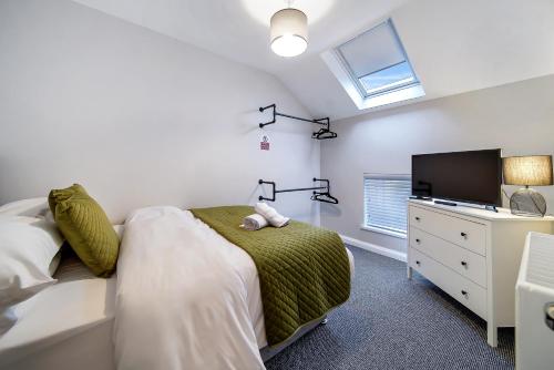 a bedroom with a bed and a flat screen tv at The Bridge Guesthouse in Maguires Bridge