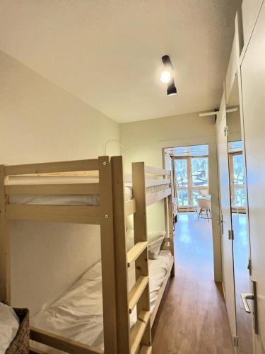 Ce dortoir dispose de lits superposés et d'un couloir. dans l'établissement Résidence Portillo - Charmant studio de 4 personnes avec vue imparable plein sud MAE-6014, à Val dʼIsère