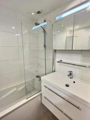 une salle de bain blanche avec un lavabo et une douche dans l'établissement Résidence Portillo - Charmant studio de 4 personnes avec vue imparable plein sud MAE-6014, à Val dʼIsère