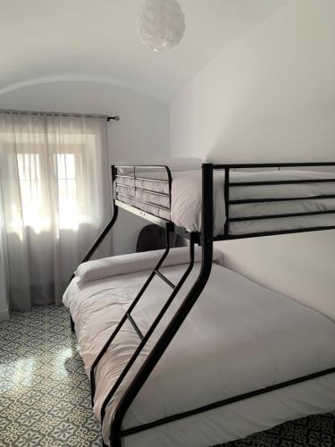 two bunk beds in a room with a window at La Casa de La Lala in Olivenza