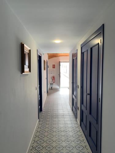 a hallway with blue doors and a tile floor at La Casa de La Lala in Olivenza