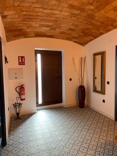 a room with a wooden ceiling and a door at La Casa de La Lala in Olivenza