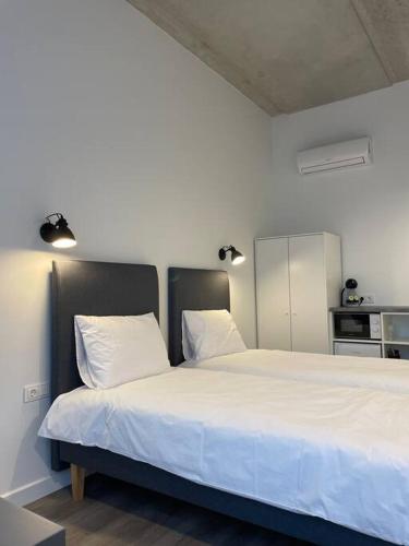 ein Schlafzimmer mit einem großen weißen Bett mit zwei Kissen in der Unterkunft Apartment Loftas13-5 in Kretinga