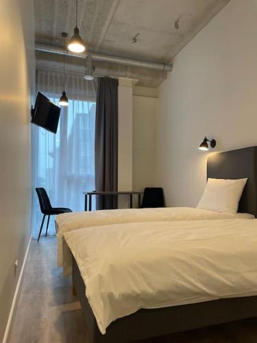 Schlafzimmer mit einem Bett und einem Tisch mit Stühlen in der Unterkunft Apartment Loftas13-5 in Kretinga