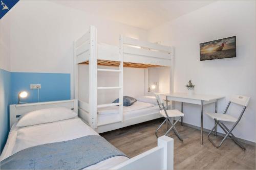 a small bedroom with a bunk bed and a desk at Ferienanlage Sonneninsel Haus Sonnenschein Erdgeschoss in Loddin