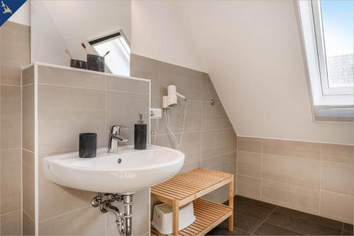 ein Bad mit einem Waschbecken und einem Spiegel in der Unterkunft Ferienanlage Sonneninsel Haus Himmelblau Obergeschoss in Loddin