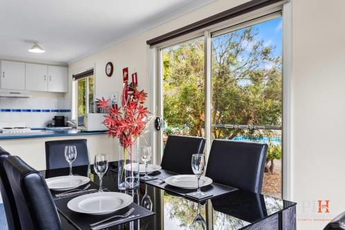 a kitchen and dining room with a table and chairs at Phillip Island Family Resort 3 BDR in Cowes