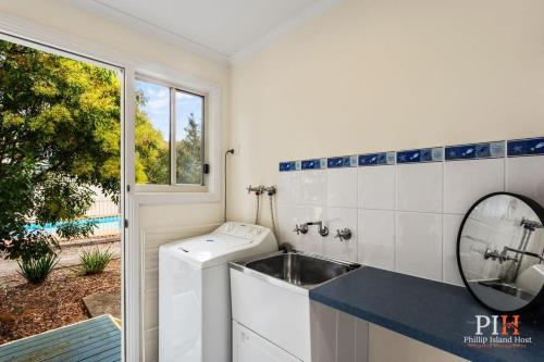 y baño con lavadora y lavamanos. en Phillip Island Family Resort 2Bdr, en Cowes