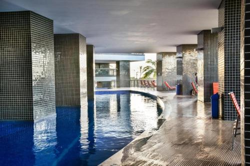 a large swimming pool with blue water in a building at 2201 - Vista mar lateral! Apto para 5 pessoas com ar e vaga in Fortaleza