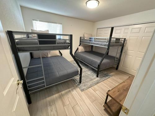 two bunk beds in a room with a door at Grand Havasu Oasis with Custom Pool & Spa! in Lake Havasu City