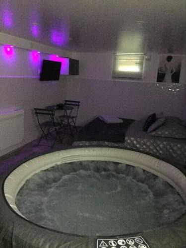 Cette chambre dispose d'une grande baignoire et d'un éclairage violet. dans l'établissement SPA L'angelus, à Saint-Germain-lès-Corbeil