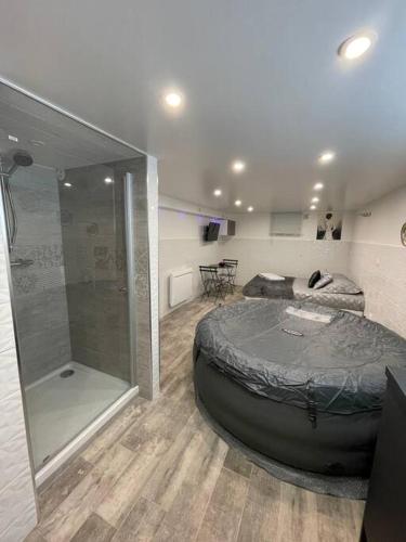 une chambre avec un grand lit et une douche dans l'établissement SPA L'angelus, à Saint-Germain-lès-Corbeil