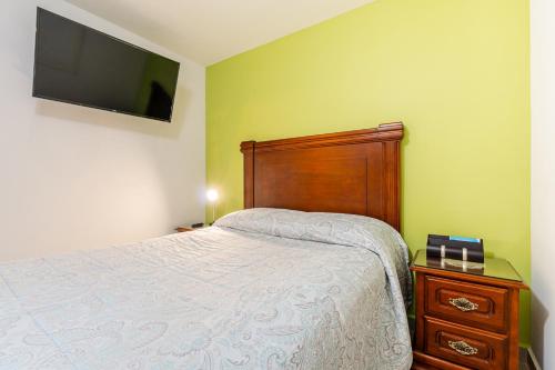 a bedroom with a bed and a tv on the wall at DEPARTAMENTO COMPLETO COYOACAN in Mexico City