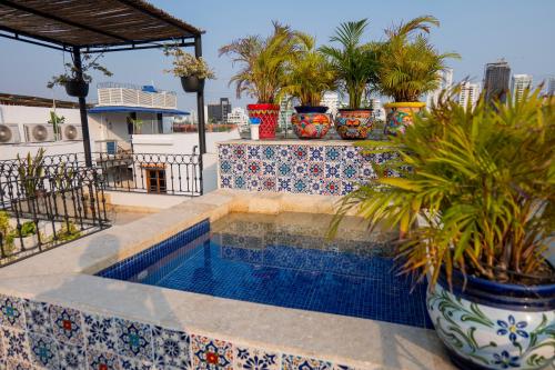 a swimming pool with potted plants on top of a building at Casa Familiar - Maria de las Palmas -Getsemani in Cartagena de Indias