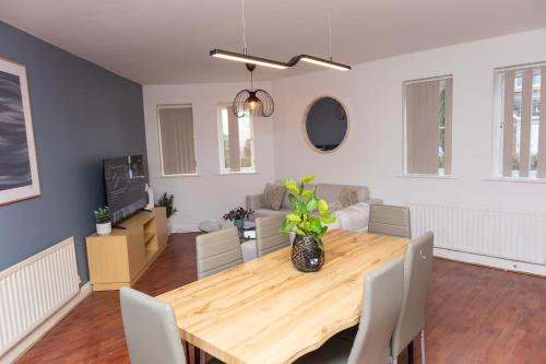 a living room with a wooden table and a couch at Caasi home Gorton Manchester in Manchester