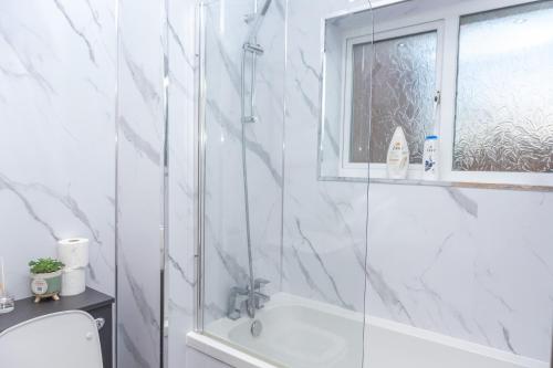 a white bathroom with a shower and a sink at Caasi home Gorton Manchester in Manchester