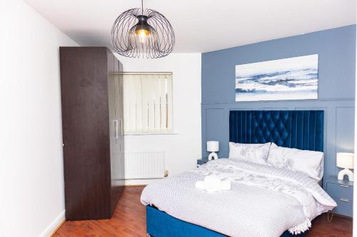 a bedroom with a bed with a blue headboard at Caasi home Gorton Manchester in Manchester
