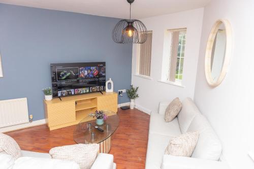 a living room with a white couch and a tv at Caasi home Gorton Manchester in Manchester