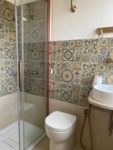 y baño con ducha, aseo y lavamanos. en Casa Vacanze Sharazad en Bocchignano