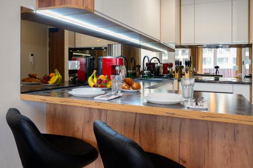 a kitchen with two chairs and a counter with food on it at Ekskluzywny apartament + garaż in Kraków