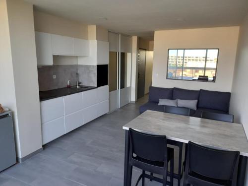 une cuisine et un salon avec une table et des chaises dans l'établissement Cap Agde Naturiste YETANATU, au Cap d'Agde
