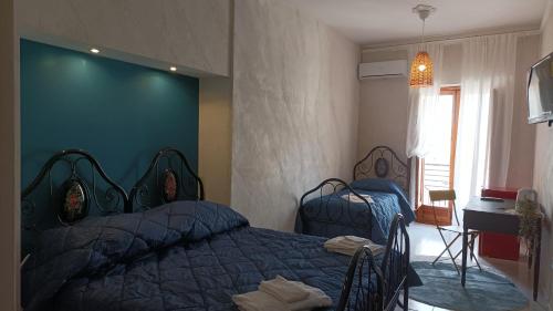 a bedroom with two beds and a blue wall at Palazzo montagna in Grotte