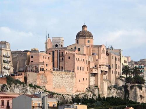 um grande edifício ao lado de uma montanha em Castello's Rooms em Cagliari