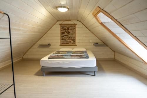 1 cama en el medio de una habitación en un ático en Chez tonton Henri, maison de pêcheur, en Saint-Valery-sur-Somme