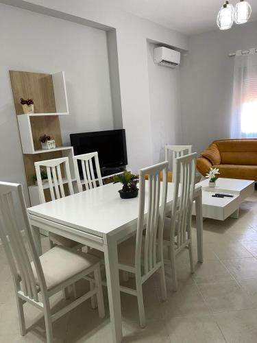 a white dining table and chairs in a living room at BB City Hall in Vlorë