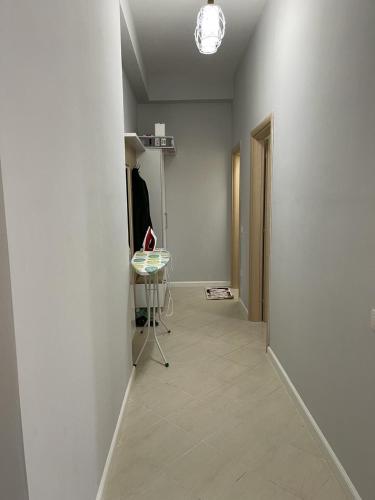a hallway with a white wall and a table in a room at BB City Hall in Vlorë