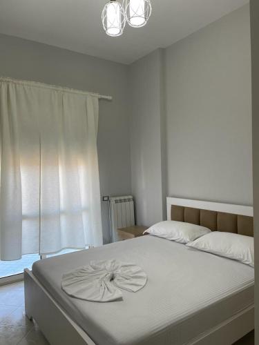 a bedroom with a white bed with a flower on it at BB City Hall in Vlorë