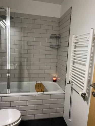 a white bathroom with a tub and a toilet at Apartment in Hafnarfjörður in Hafnarfjördur