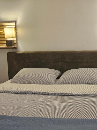 a bed with white sheets and pillows in a room at Apartman Pontica in Kotor