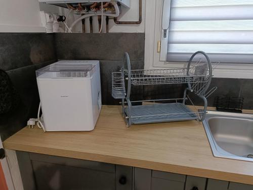 - un comptoir de cuisine avec un séchoir à vaisselle à côté d'un évier dans l'établissement Maison de ville avec extérieur au calme., au Havre