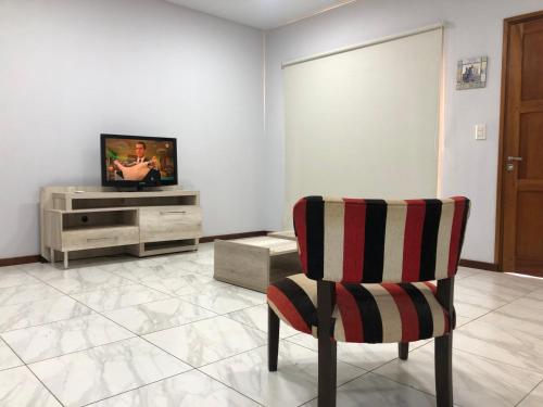 sala de estar con silla y TV en Argerich en Eldorado