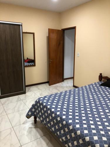 Un dormitorio con una cama azul y blanca y un espejo en Argerich en Eldorado