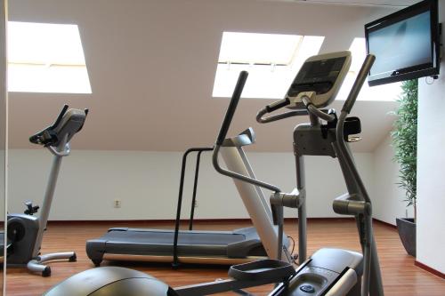 a gym with two exercise bikes and a flat screen tv at Bastion Hotel Maastricht Centrum in Maastricht