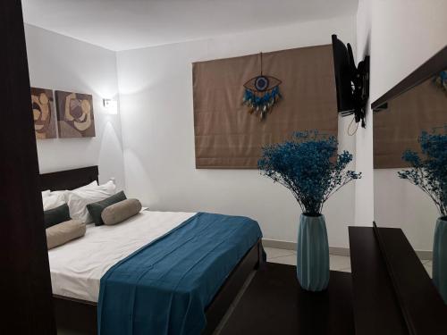 a bedroom with a bed and a vase with flowers at Melia Dunas Ilha do Sal Apartamentos in Santa Maria