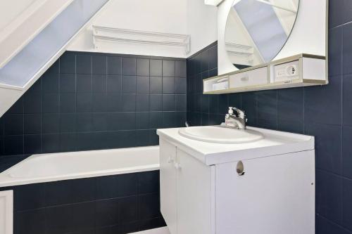 La salle de bains est pourvue d'un lavabo et d'un miroir. dans l'établissement Appart hyper centre Rueil rénové !, à Rueil-Malmaison