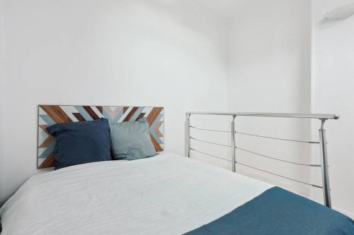 - une chambre avec un lit et des oreillers bleus dans l'établissement Appart hyper centre Rueil rénové !, à Rueil-Malmaison