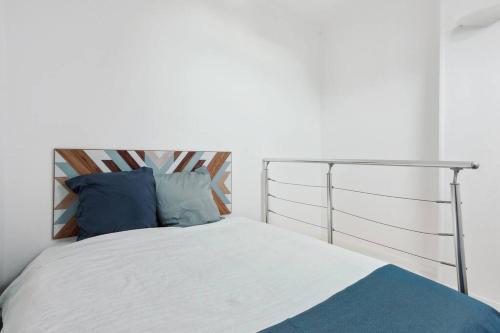 une chambre avec un lit avec des oreillers bleus dans l'établissement Appart hyper centre Rueil rénové !, à Rueil-Malmaison
