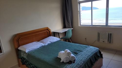 Tempat tidur dalam kamar di Frente Mar - Apartamento para 4 Hóspedes com Home Office Wi-Fi 200mbps, Ar Condicionado e Cozinha Completa
