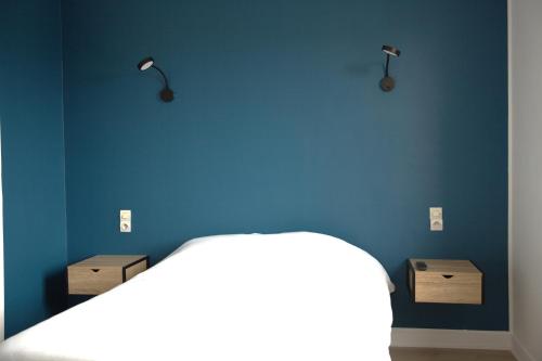 um quarto com uma parede azul e uma cama com 2 caixas em RELAIS 375 em Couhé-Verac