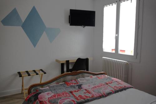 RELAIS 375 في Couhé-Verac: غرفة نوم بسرير وتلفزيون على الحائط