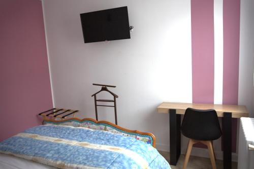 a bedroom with a bed and a desk and a television at RELAIS 375 in Couhé-Verac