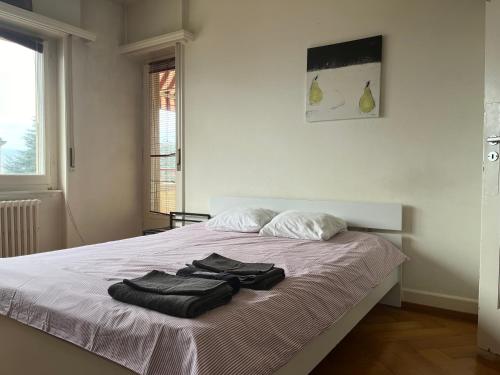 a bedroom with a bed with two towels on it at Grand Appartement avec 3 chambres à coucher in Lausanne
